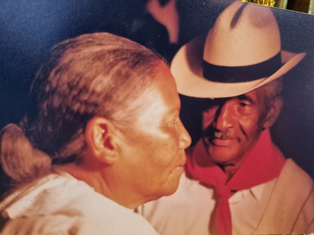 Fotografía antigua de una pareja mayor con sombrero y pañuelo rojo